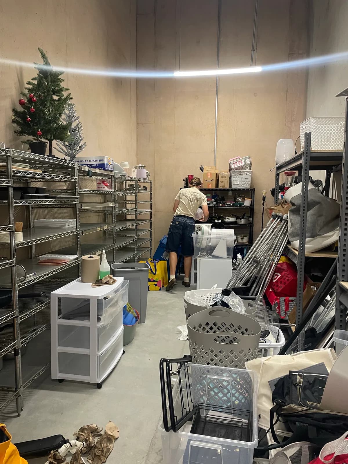 A student working among shelves of donated dorm goods in a storage room